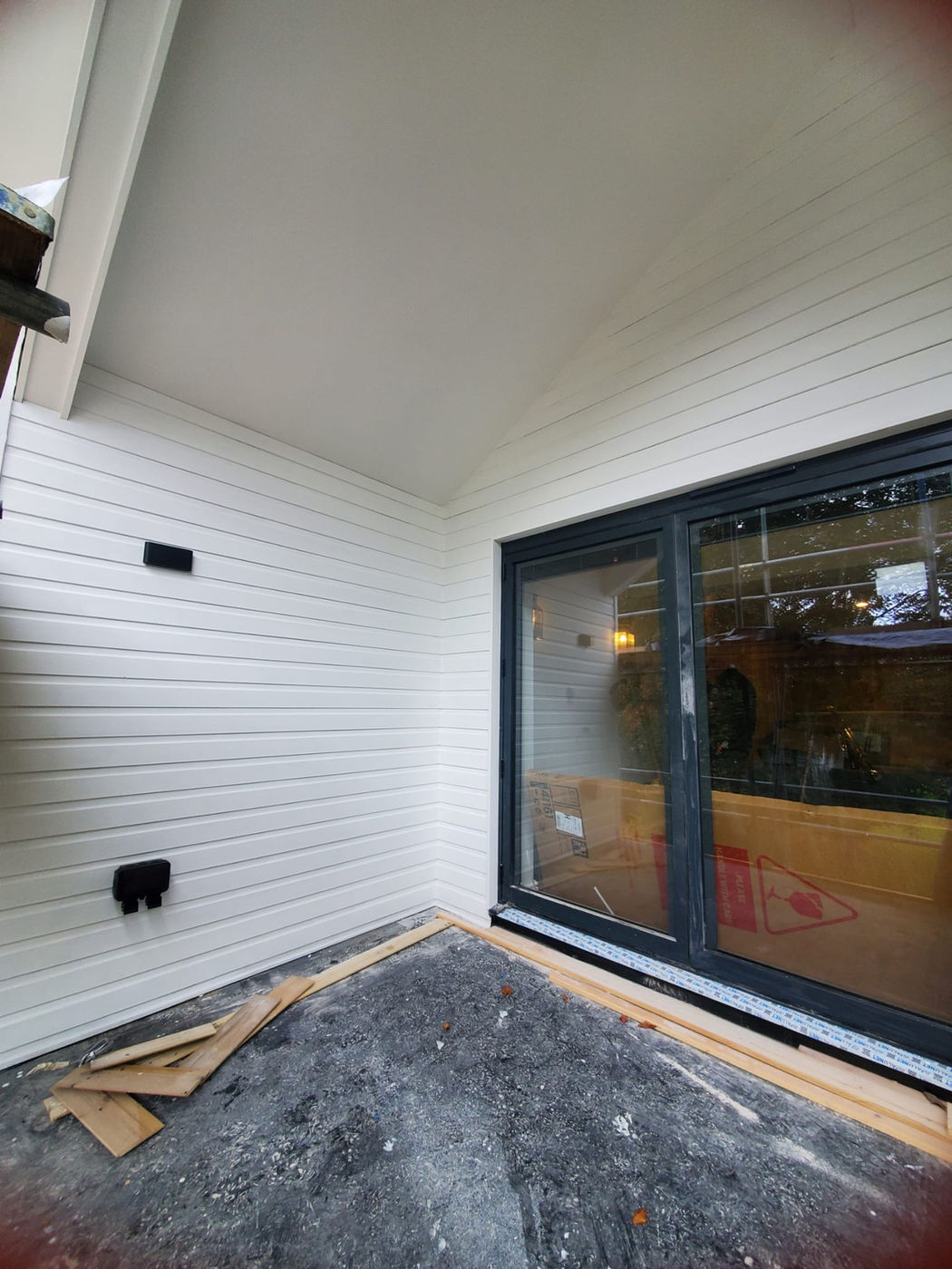 Exterior white cladding and black patio door finishing work by Samson Handyman
