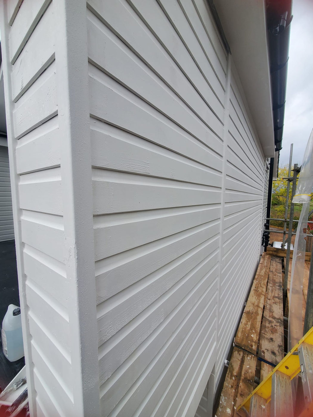 Close view of white exterior cladding fitted along a wall