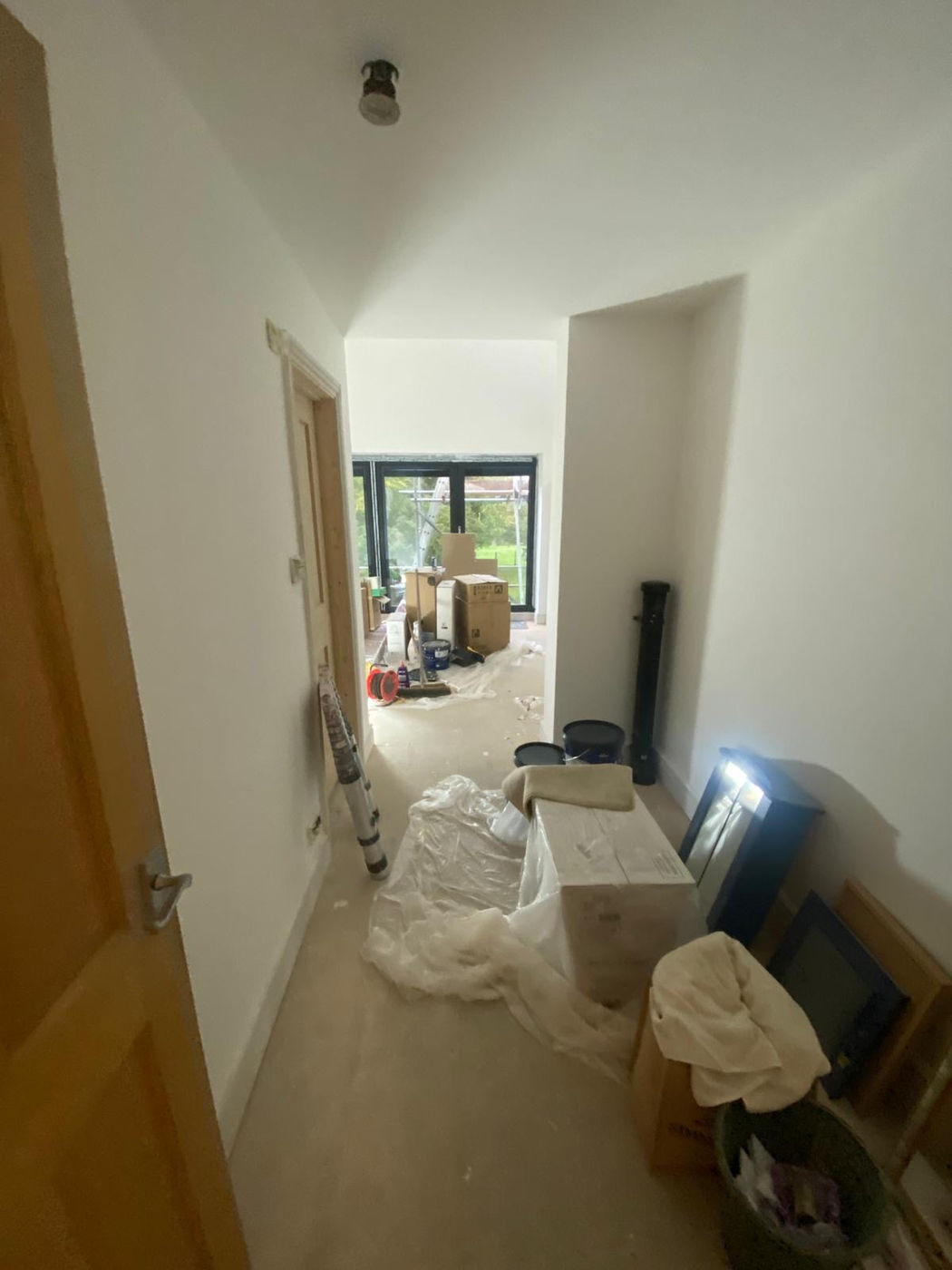 Hallway and room prepared for decorating with dust sheets and tools