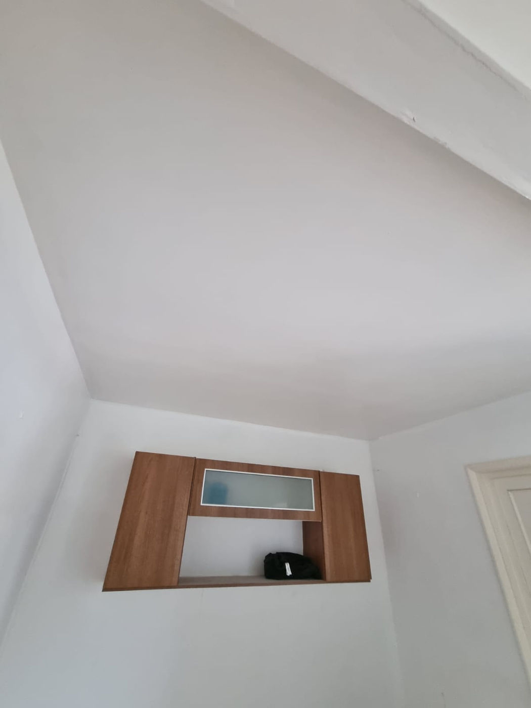 Smooth white ceiling and wall finish above an internal door