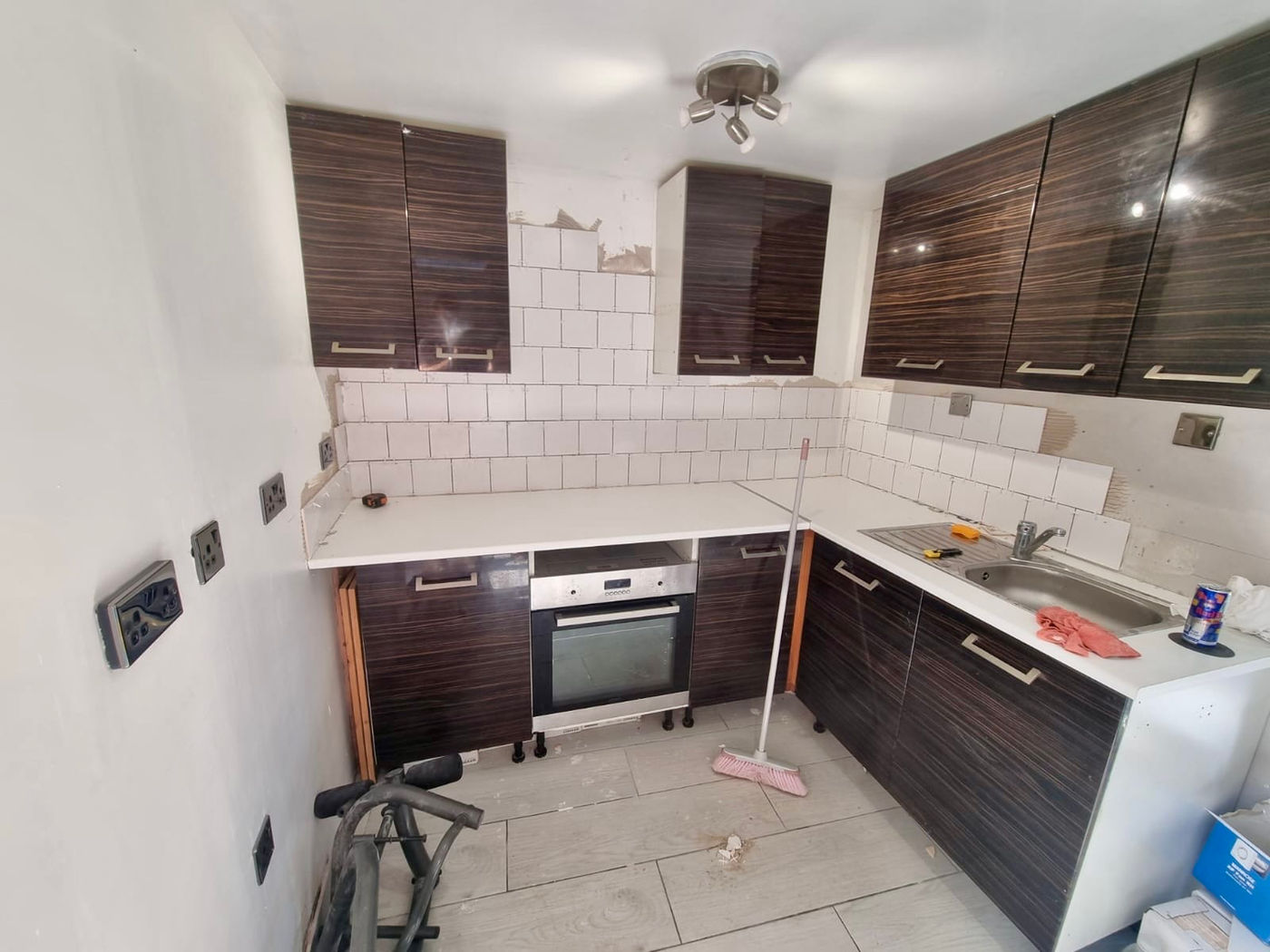 Kitchen tiling and cabinet work in progress with wider room view