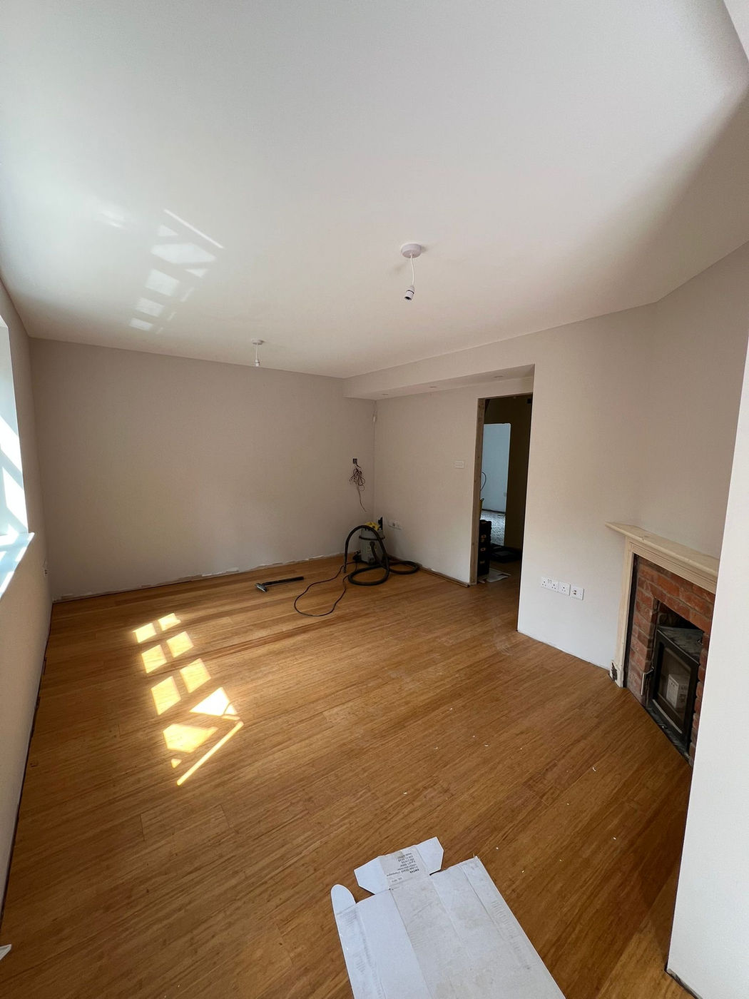 Room with wood flooring and wall preparation around a fireplace