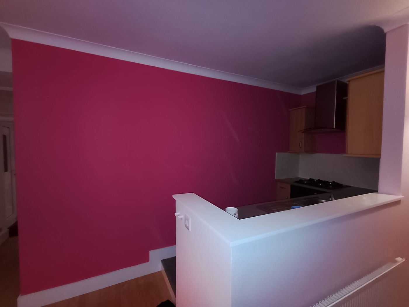Decorated room with pink feature wall and white stair balustrade