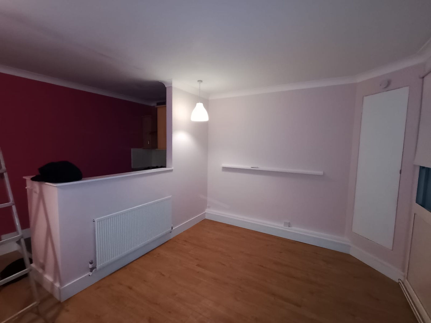 Finished room with curved wall, painted surfaces and wood flooring