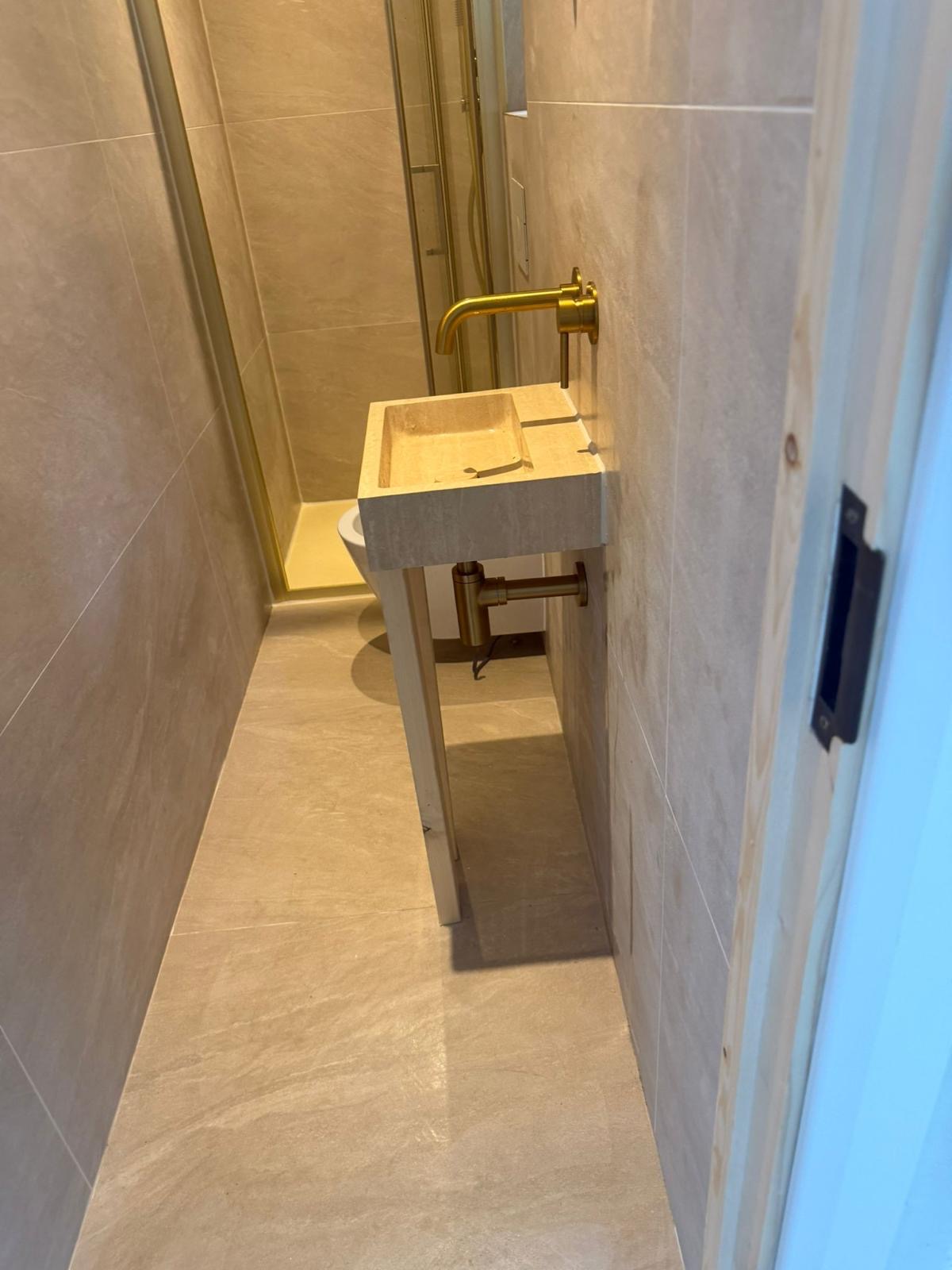 Compact tiled cloakroom with wall-mounted basin completed by Samson Handyman