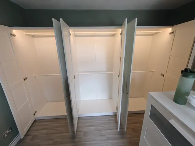 Fitted wardrobe assembly with doors open, internal rails and shelving
