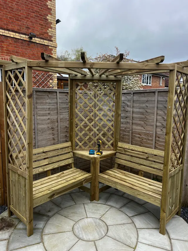 Garden pergola seating and timber frame assembled on a paved patio